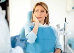 Personne dans un cabinet de dentiste qui se tient la machoire