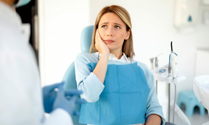 Personne dans un cabinet de dentiste qui se tient la machoire